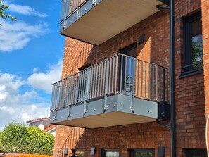 A multi-story building with a brick facade and balconies with metal railings. - Old Town Apartment - The Vacation Rental in the Center of Sulingen (Sulingen)