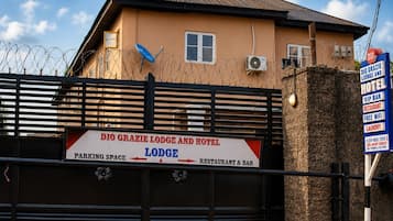 A gated entrance to DIO Grazie Lodge and Hotel with a sign indicating parking space, lodge, and restaurant & bar areas.