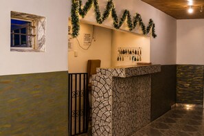A reception area with a stone-textured counter, a wooden ceiling, and a wall-mounted sign. - Diograzie Hotel (Benin City)