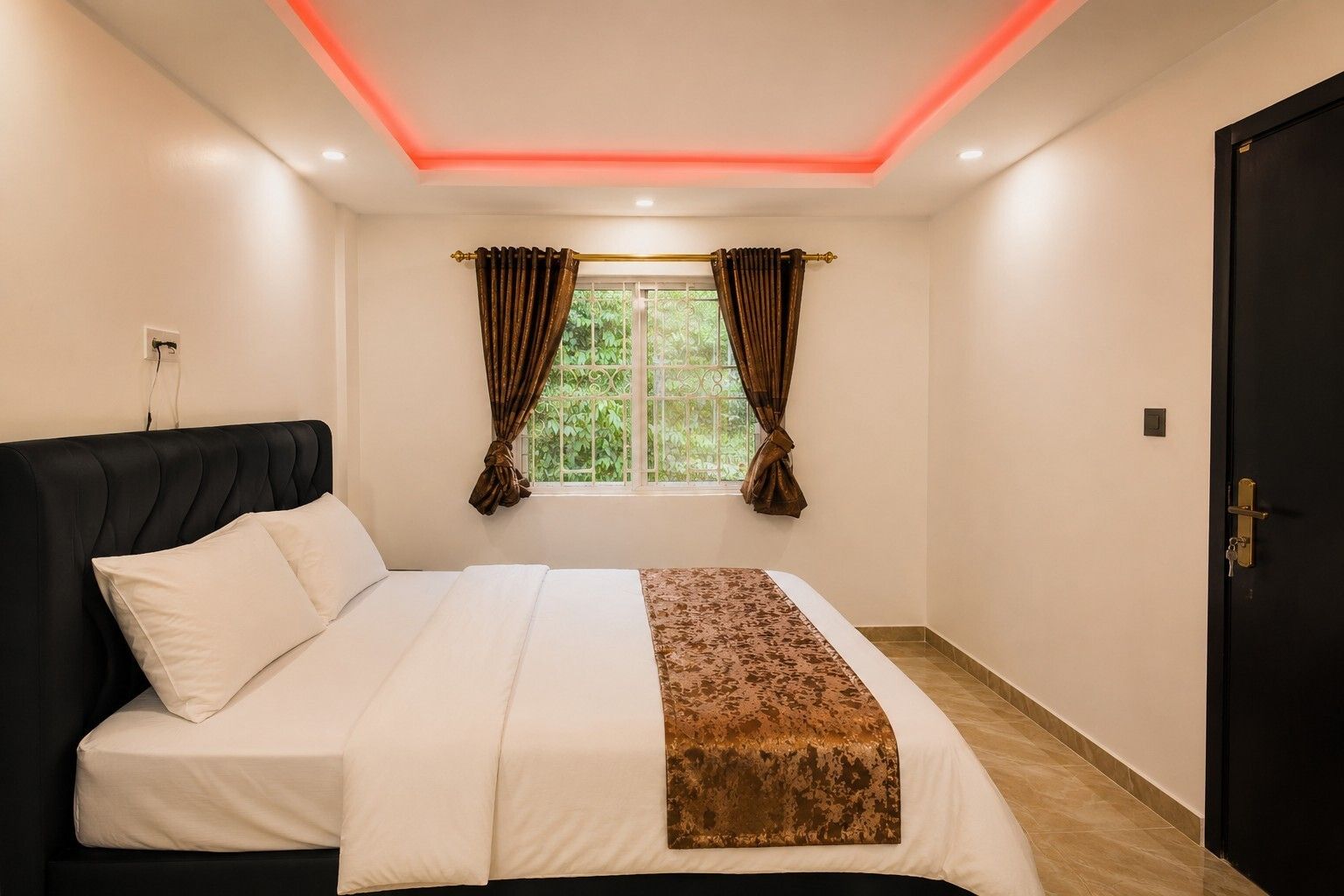A bedroom with a bed, curtains, a window, and a door.