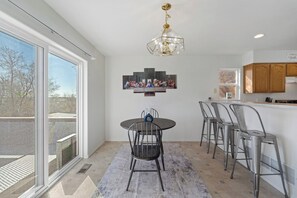 Una cocina moderna con comedor, ventanas amplias y una araña.