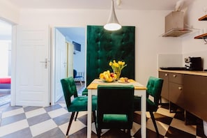 A dining area with a table, chairs, and a vase of flowers. - Kings City Zyblikiewicza 5  (Kraków)