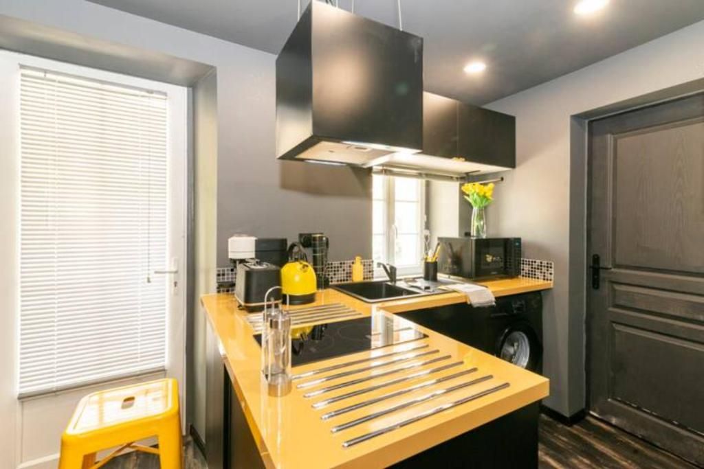 A compact kitchen with a central island, a microwave, a kettle, and a sink.