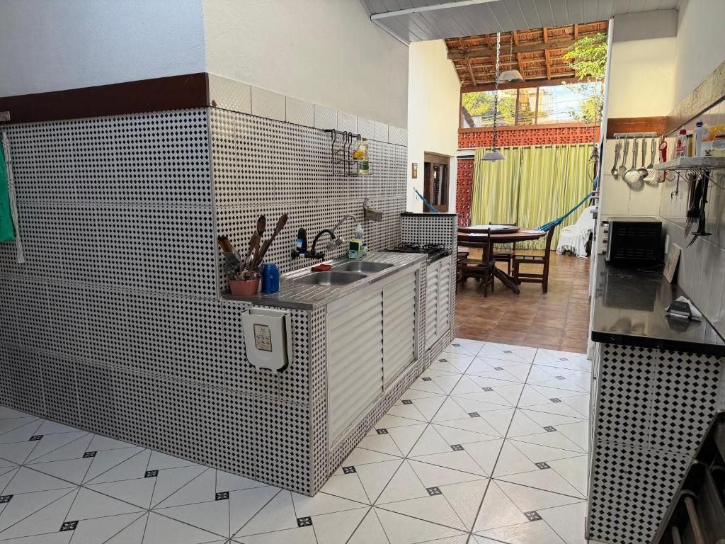 A kitchen with a tiled backsplash, a sink, and a dining area with a table and chairs.