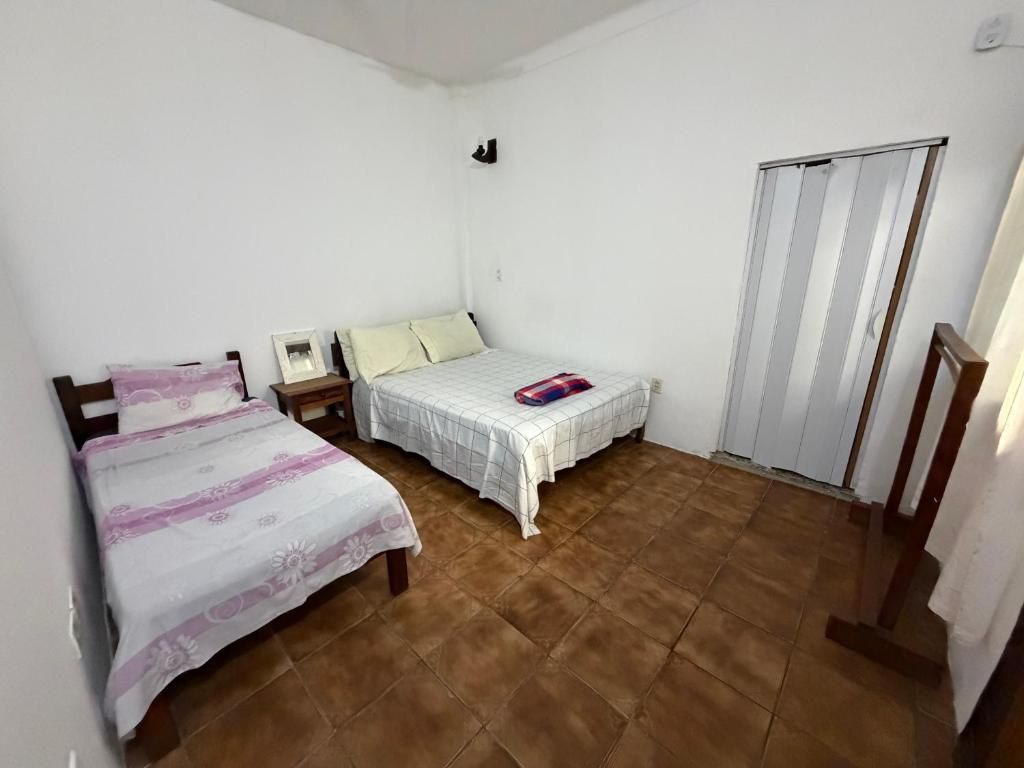 A room with two beds, a wardrobe, and a sliding door.