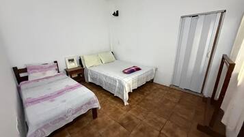 A room with two beds, a wardrobe, and a sliding door.