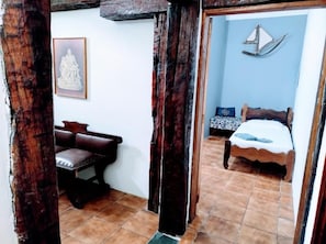 A room with a bed, a bench, and a wall-mounted sculpture. - Pousada Villavera (Caraguatatuba)