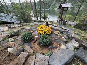 A garden with a pond, rocks, and a wooden structure. - The Bear Lair - timber frame lake retreat in Wildwood’s private 740ac. community (Tolland)