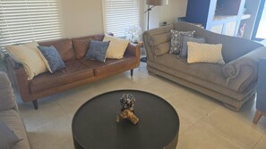 Sala de estar com dois sofás, uma mesa de centro e um abajur.