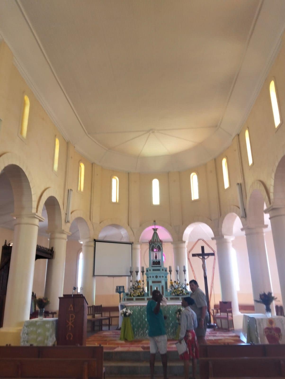 A church interior with arched ceilings, a pulpit, and a central altar.