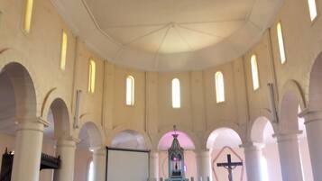 A church interior with arched ceilings, a pulpit, and a central altar.
