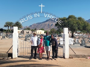 Un cementerio con una cruz en la entrada y cielo despejado.