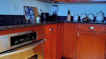 A kitchen with wooden cabinets, a built-in oven, and a microwave.