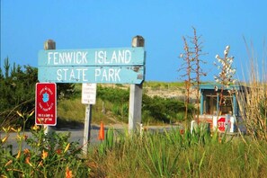 Señal de parque estatal con la inscripción 'FENWICK ISLAND STATE PARK' y un letrero que indica 'NO ESTACIONAR'.