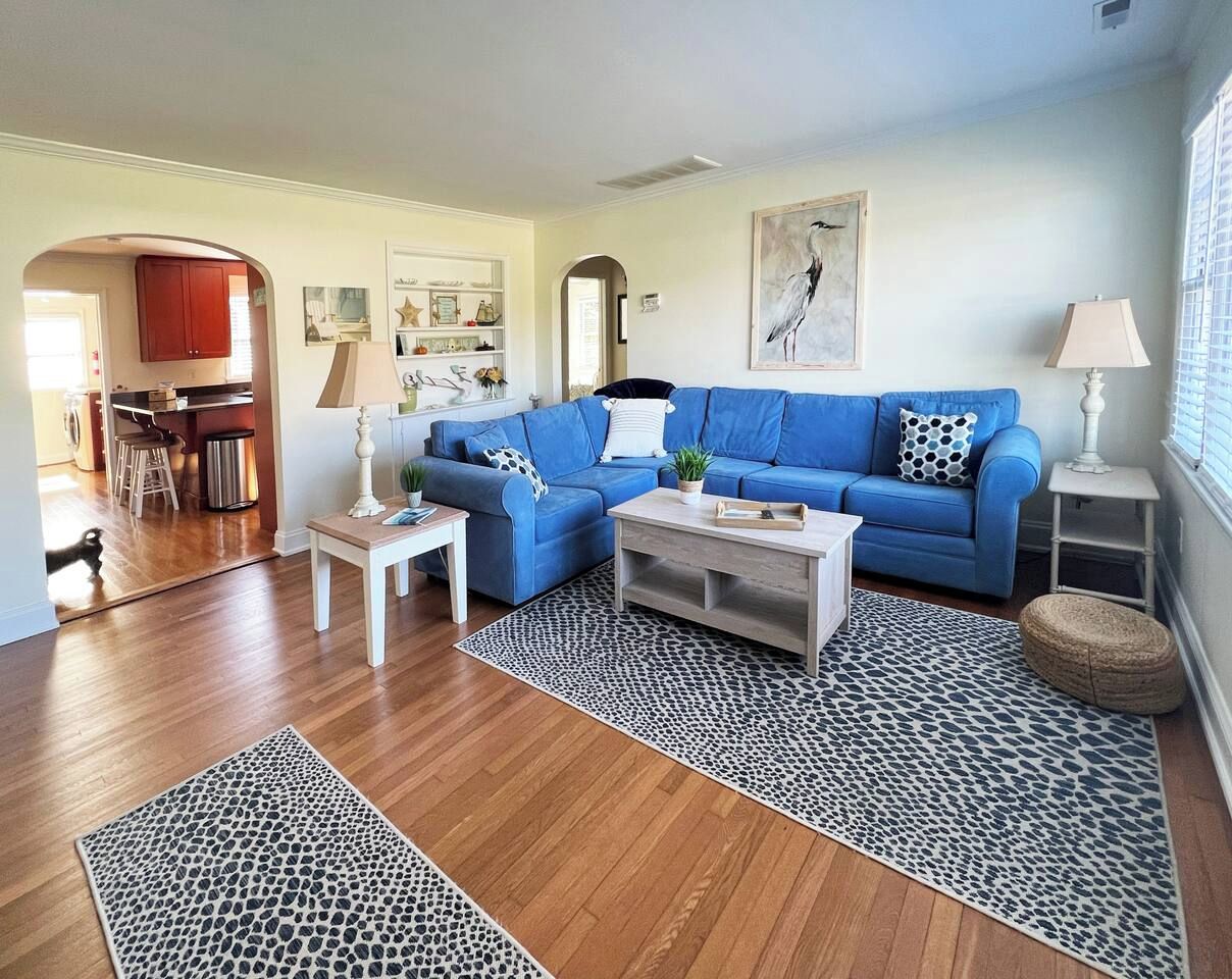 A living room with a blue sofa, a coffee table, and a patterned rug.