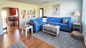 A living room with a blue sofa, a coffee table, and a patterned rug.