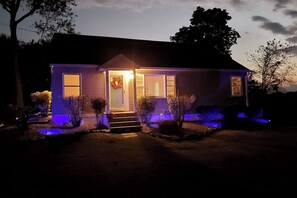 A house with a front porch, a door with a wreath, and a small step leading up to the entrance.