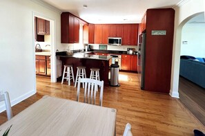 A modern kitchen with wooden cabinets, a stainless steel refrigerator, and a built-in microwave.