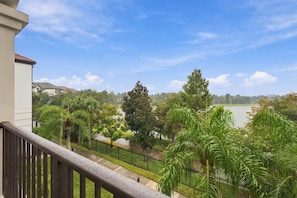 A balcony with a view of a lake, surrounded by greenery and a clear sky. - 3BR at Vista Cay, where Comfort meets Convenience (Orlando)
