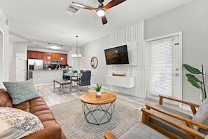 A modern living room with a sofa, coffee table, and a TV mounted on the wall. - 3BR at Vista Cay, where Comfort meets Convenience (Orlando)