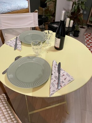 A dining table set with plates, cutlery, glasses, and a bottle of wine. - PAOLO'S CHARMING APARTMENT (Puteaux)
