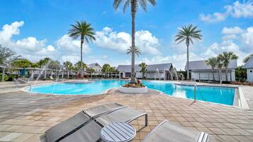 A pool area with lounge chairs and palm trees.