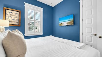 Un dormitorio con cama, ventana con contraventanas y puerta.