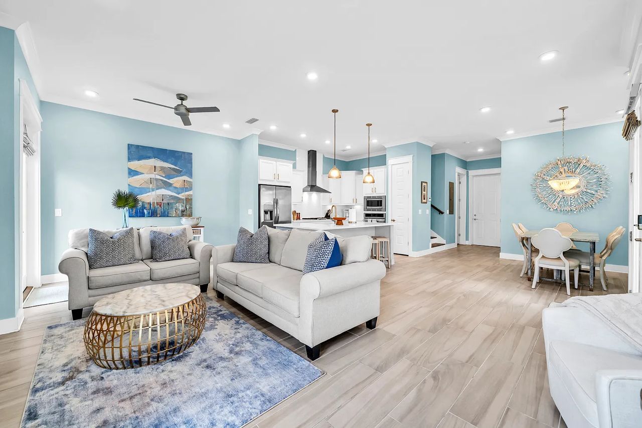 A modern living room with a sofa, coffee table, and dining area.