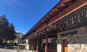 A building with a stone facade and a wooden overhang. - La Mongie 1800 – At the base of the slopes, balcony, in the heart of the resort – Sleeps 6 (Bagnères-de-Bigorre)