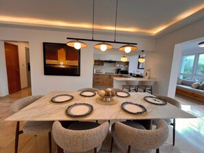 A modern dining area with a marble table, woven chairs, and pendant lighting. - The Amber Haven V. (Samana)