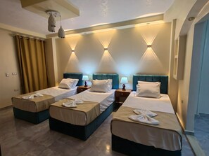 A hotel room with two beds, a ceiling fan, and wall-mounted lighting. - Gem& pyramids front  (Giza)