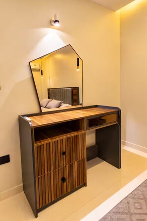 A modern vanity with a mirror, wooden paneling, and a built-in shelf. - Hotel Apartment 10 minutes away from The Airport (Cairo Governorate)