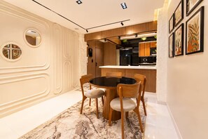 A modern kitchen with wooden cabinets, a black countertop, and a built-in oven. - Hotel Apartment 10 minutes away from The Airport (Cairo Governorate)
