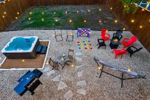 A backyard with a hot tub, seating area, and outdoor games. - Luxe Living in the heart of Dallas (Dallas)