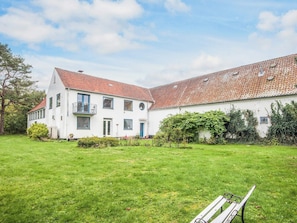 A two-story building with a red-tiled roof, a white facade, and a grassy yard. - 5 Person Holiday Home in Laeso (Læsø)