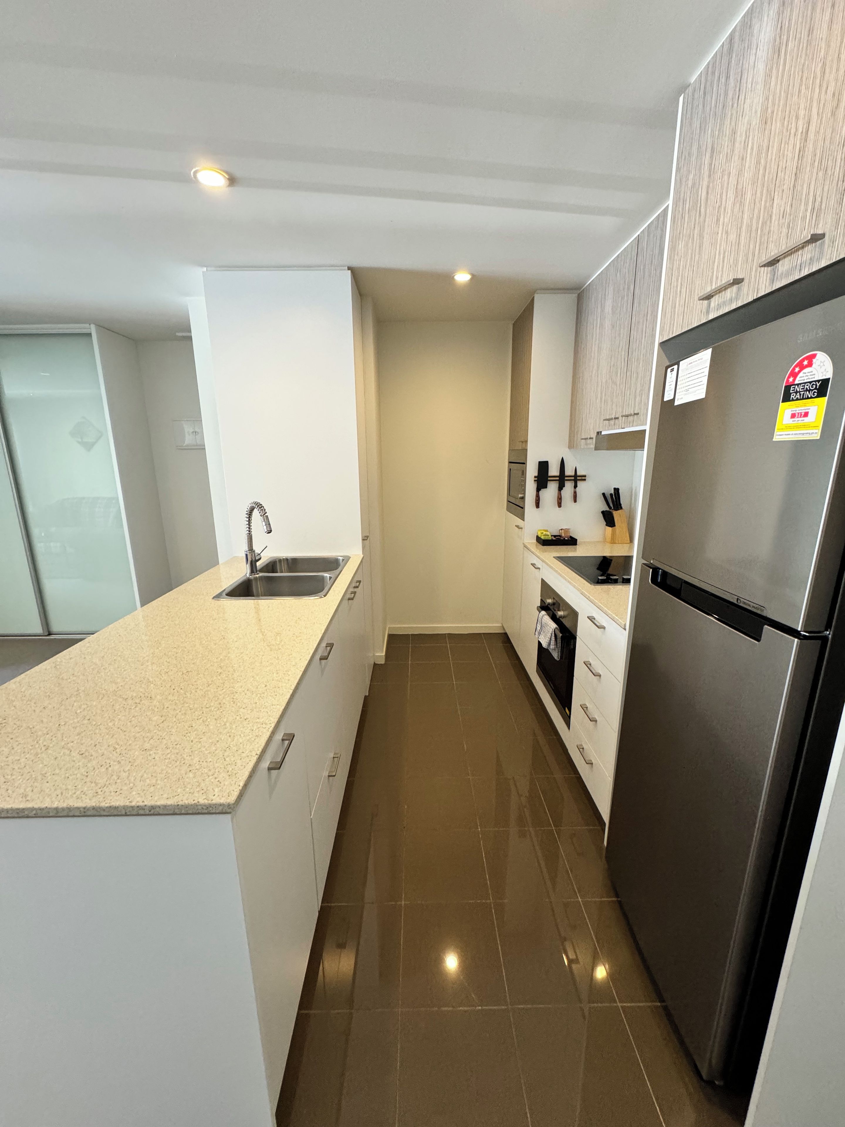 A modern kitchen with a stainless steel refrigerator, a sink, and a countertop.
