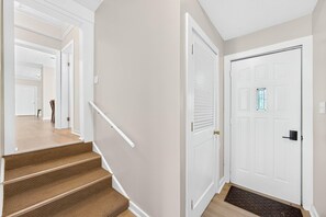 Eine Treppe führt zu einer Zwischenebene mit einer Tür und einem Fenster.