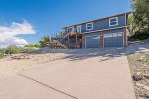 A two-story house with a front deck, a garage, and a flag. - NEW! Ridges Retreat: Pet-Friendly Stay w/Firepit (Grand Junction)