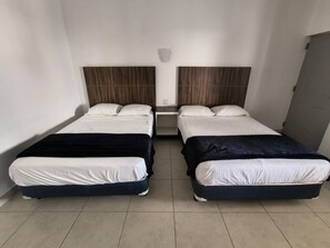 A twin room with two beds, each with a white mattress and a dark-colored headboard. - Motel Los Arcos (Caborca)