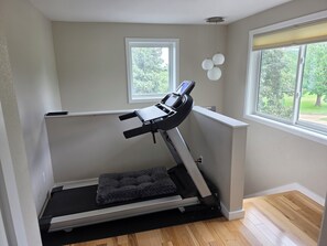 A room with a treadmill, a window, and a view of greenery outside. - Sundance 6BR  Prime Location & Space (Boulder)