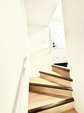 Eine Treppe mit Holzstufen und einer weißen Tür am Oberende.