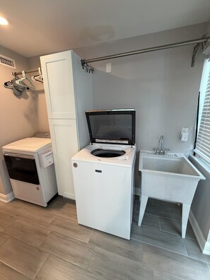A compact laundry room with a washing machine, dryer, and a small sink. - Amazing View Gulf Access 2100 Sq Ft House 3-BD Pool, Boat Lift 2 Min To Gulf Bay (Fort Myers Beach)