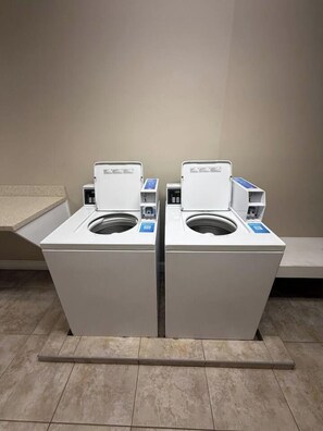 A pair of front-loading washing machines in a commercial laundry area. - Oceanside condo in Sea Side Villas on the beach. (Hilton Head Island)