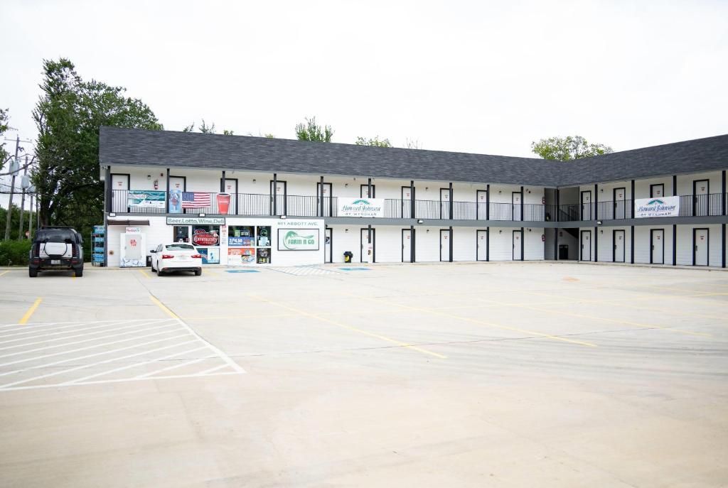 A motel with a parking lot, multiple rooms, and a storefront with various businesses.
