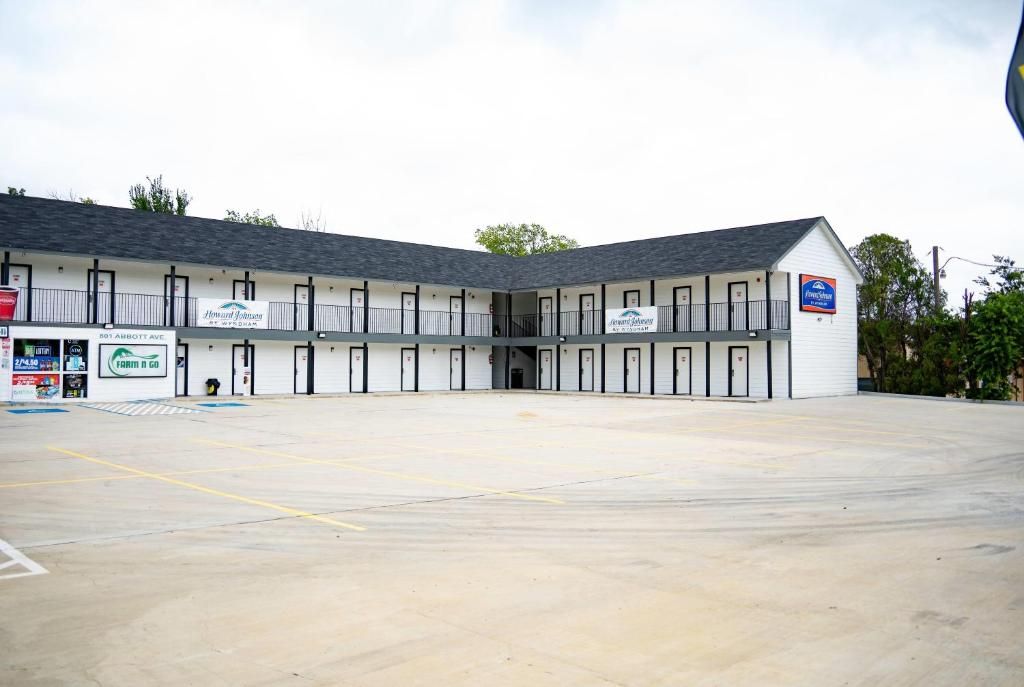 A motel with a central courtyard, multiple rooms, and a parking lot.