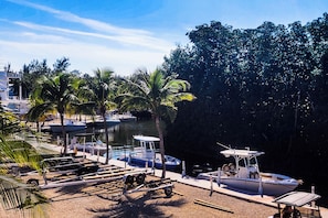 A marina with boats docked, palm trees, and a clear sky. - Turtle Nest in the Keys - Cozy RV Retreat in Key Largo - Golf Cart Included (Key Largo)