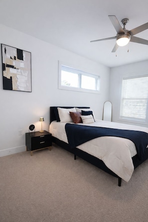 A bedroom with a bed, bedside table, lamp, and ceiling fan. - Spacious 3BR Downtown Near VCU With Private Rooftop Patio & Free Parking (Richmond)