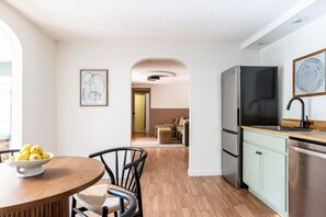 A modern kitchen with a dining area, a refrigerator, and a sink. - Spacious 2BR Near Colorado School of Mines | Workspaces + Patio (Golden)