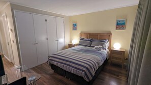 A bedroom with a bed, bedside lamps, a wardrobe, and a small table. - 18th-Floor Studio with Private Terrace & Andes Views in Providencia (Providencia)