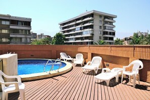 A rooftop swimming pool with lounge chairs and a view of surrounding buildings. - 18th-Floor Studio with Private Terrace & Andes Views in Providencia (Providencia)
